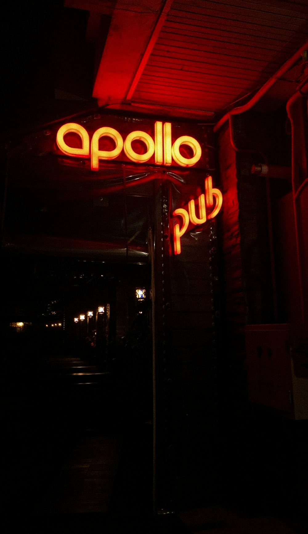 a red neon sign that reads appolo pub
