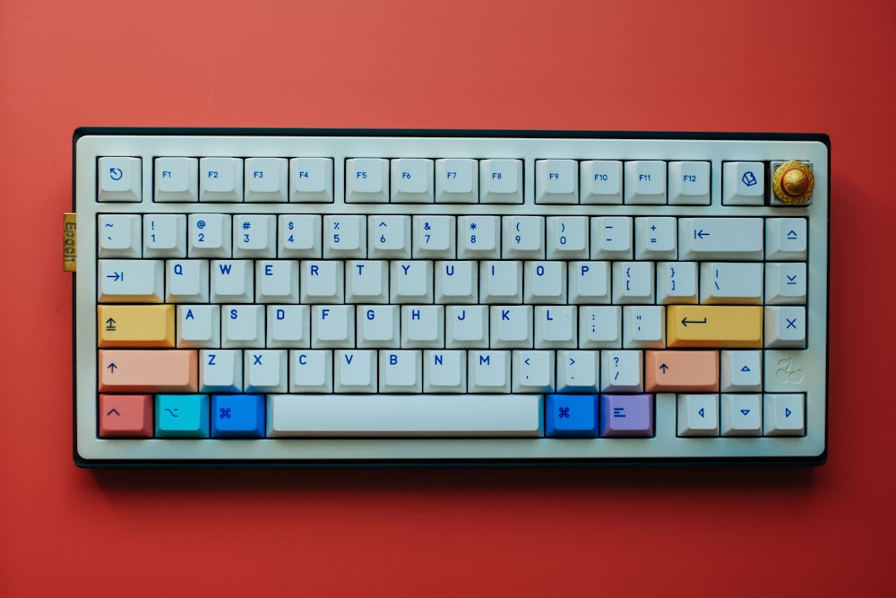 a computer keyboard with colorful keys on a red background