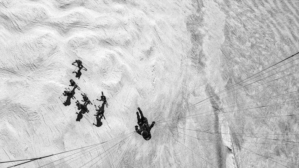a black and white photo of a group of people parasailing