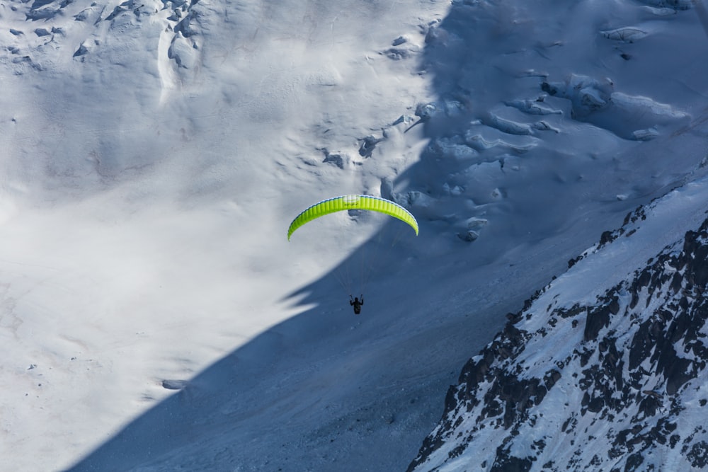 a person paragliding over a snow covered mountain