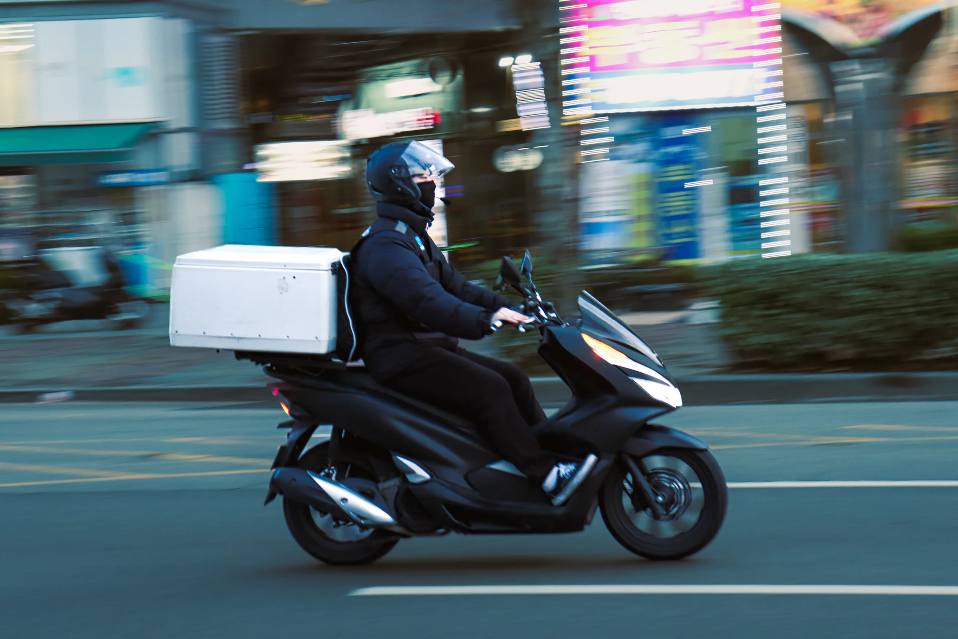 Delivery scooter with a delivery box on the road