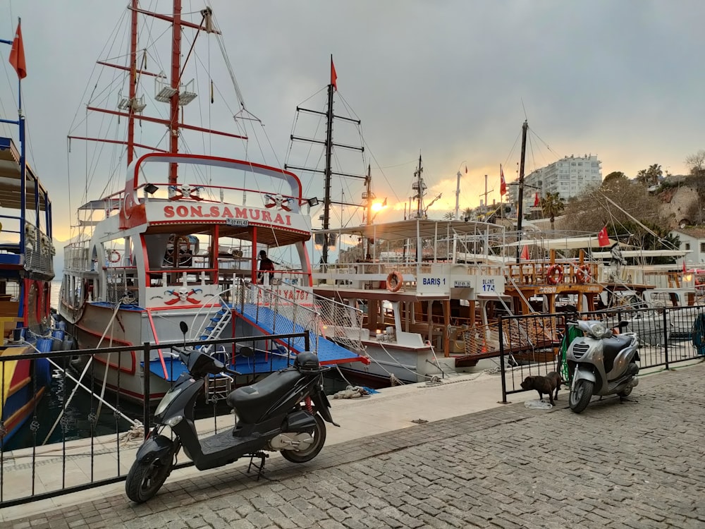 a scooter parked next to a boat in a harbor
