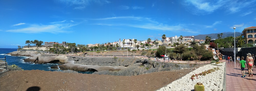 a group of people walking along a beach next to the ocean