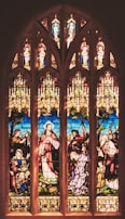 A vibrant stained glass window depicting a religious scene.