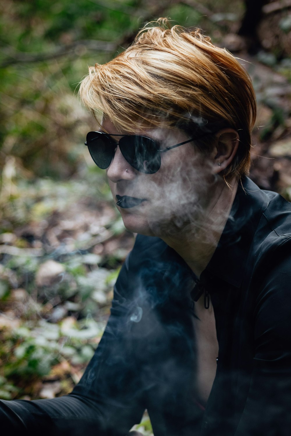 a man with red hair and sunglasses smoking a cigarette