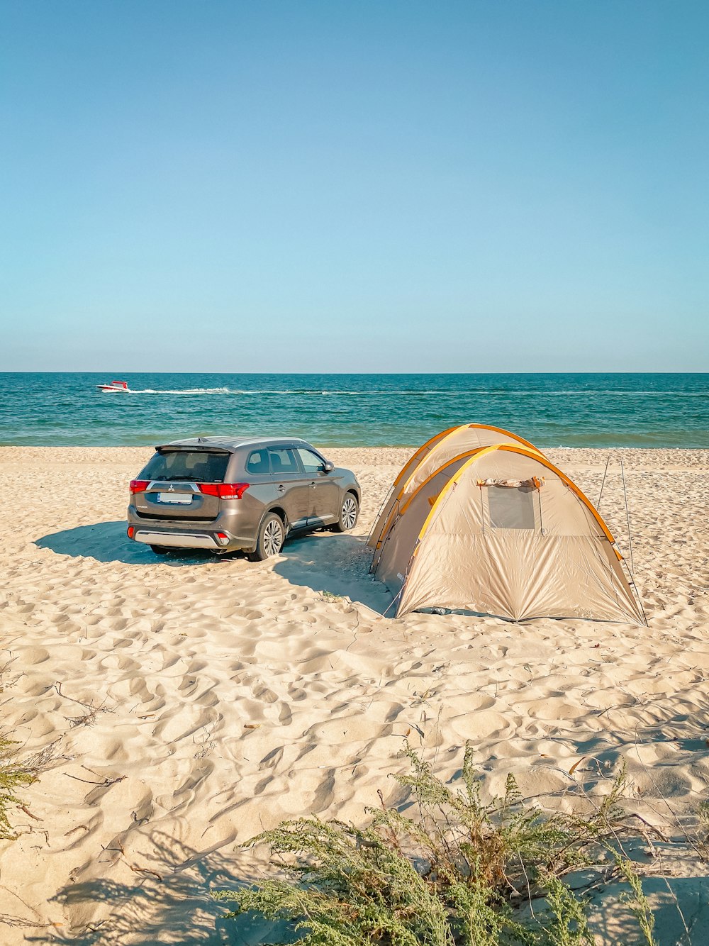 a car parked next to a tent on the beach