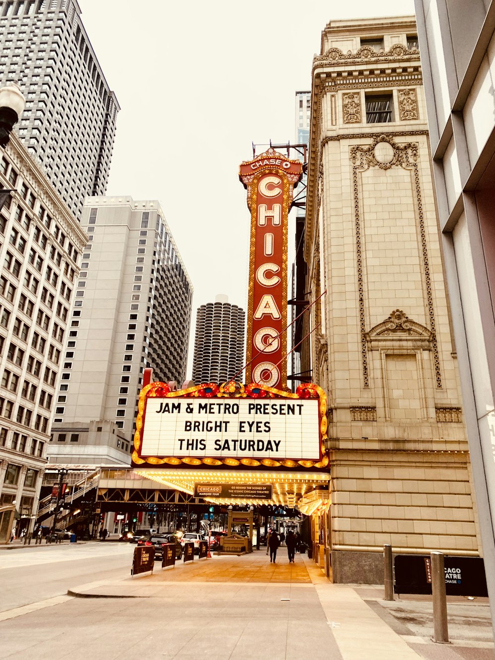 a theater marquee with a clock tower in the background