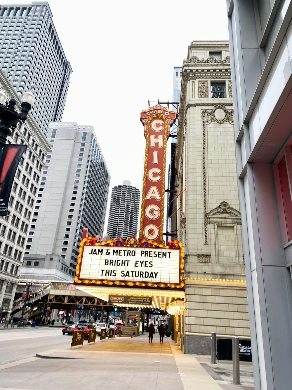 a theater marquee with a clock tower in the background