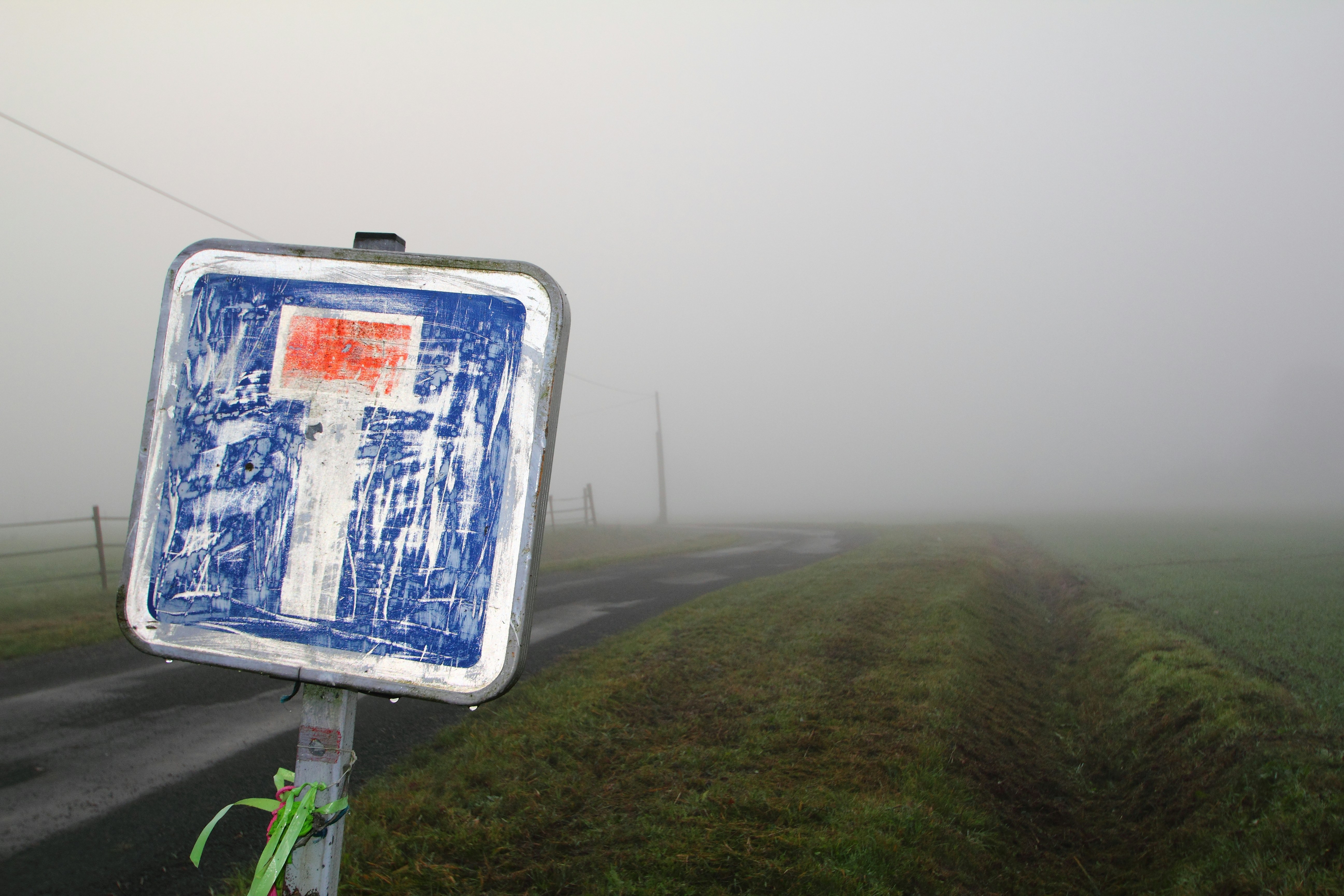 a blue and white sign sitting on the side of a road
