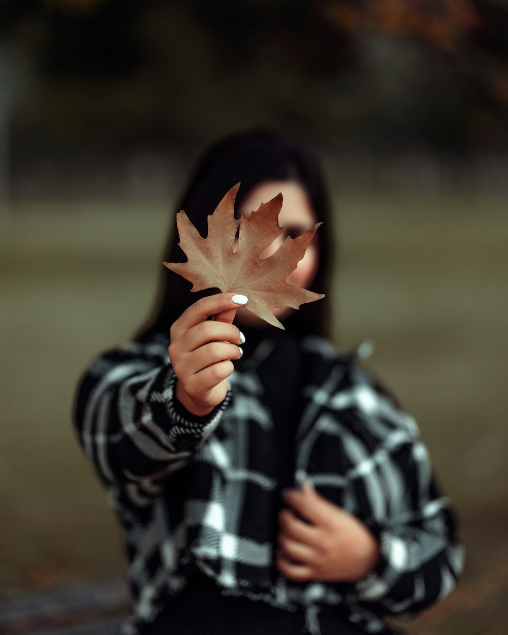 uma menina que segura uma folha em suas mãos