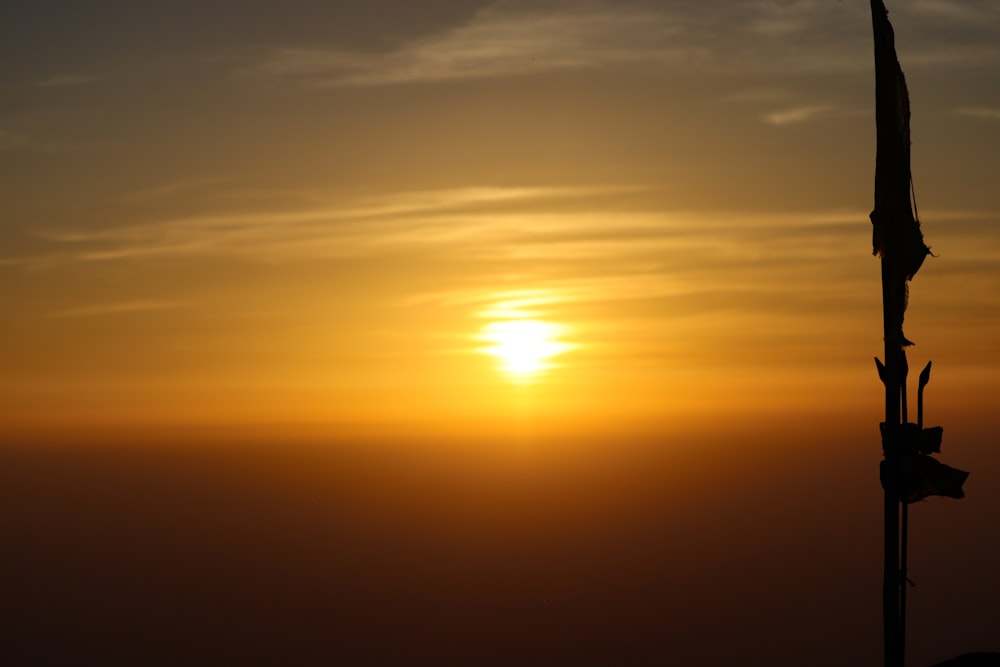 the sun is setting over the horizon of a foggy sky