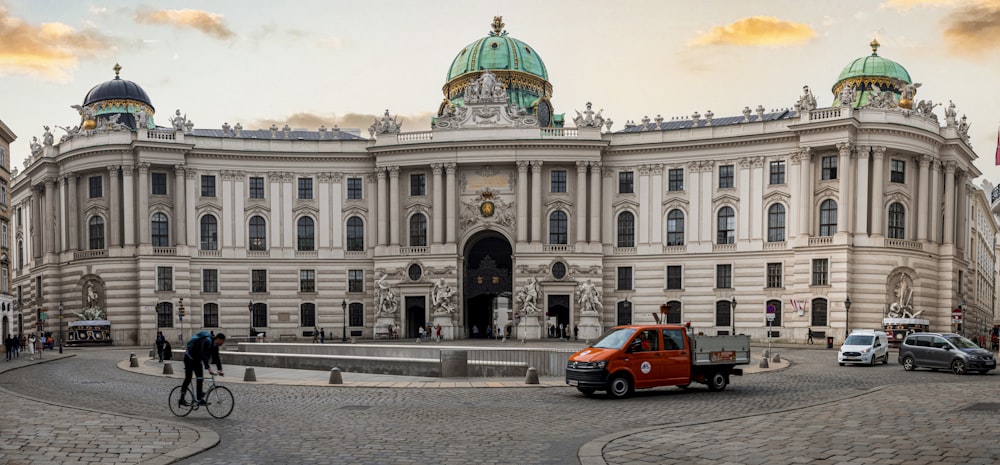 a red van is parked in front of a large building