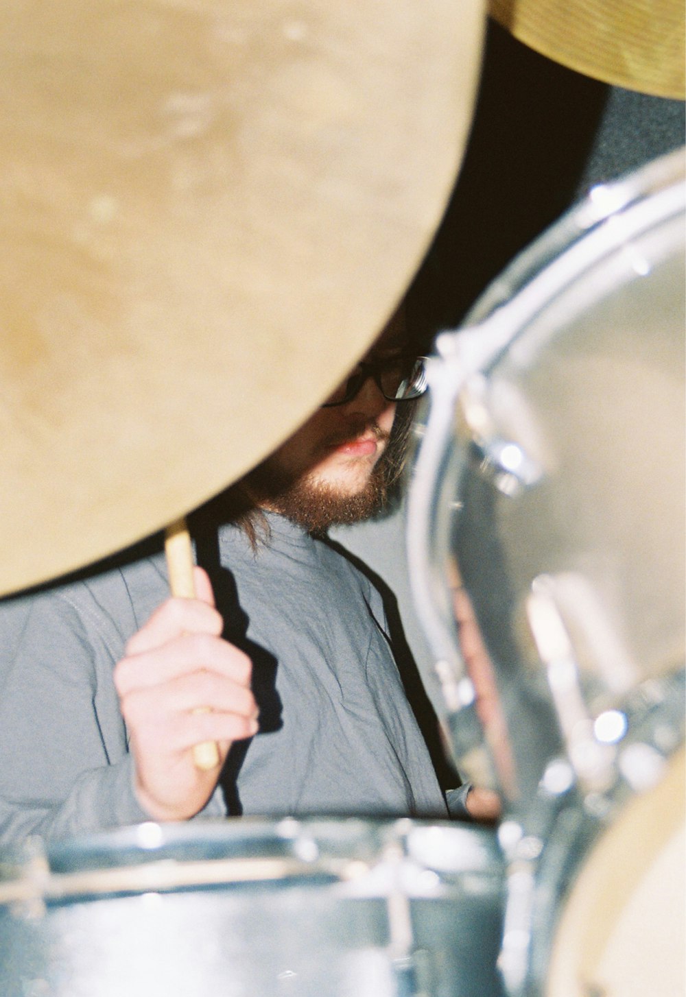 a man holding a stick in front of a drum set