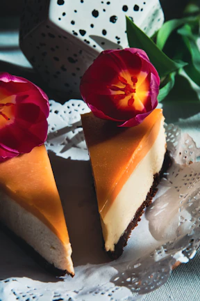 Slices of a bright lemon cheesecake decorated with edible flowers.