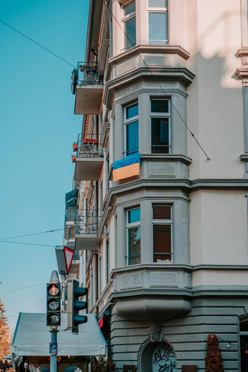 a tall white building sitting next to a traffic light