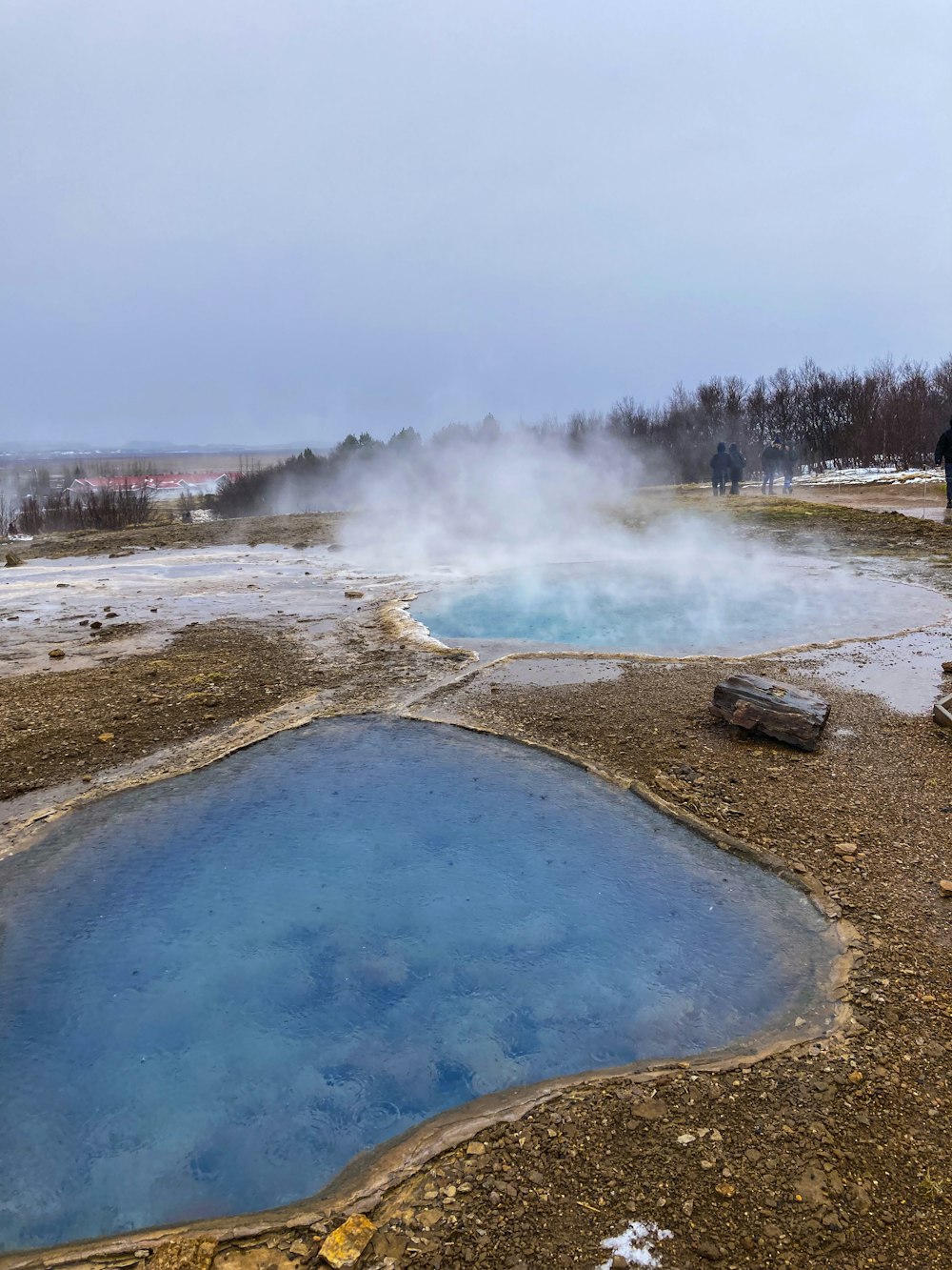 a group of people standing around a pool of water