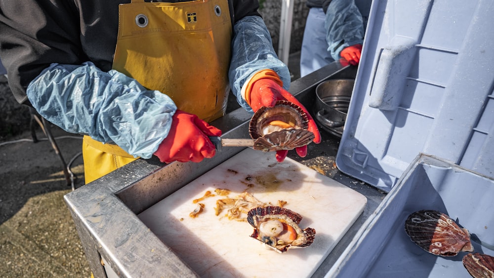 una persona cortando comida en una tabla de cortar