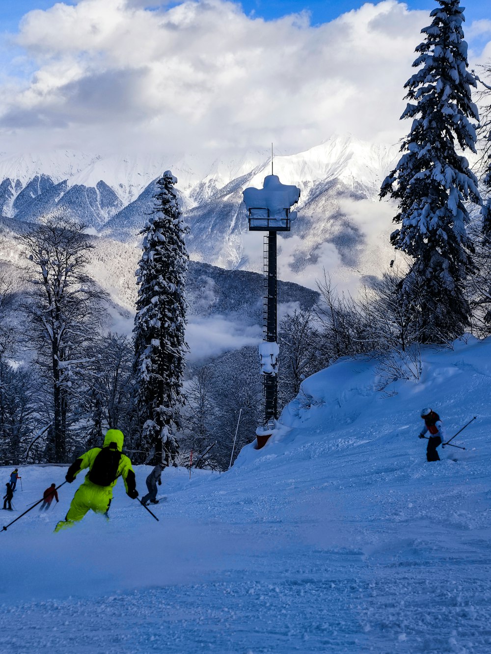 a group of people riding skis down a snow covered slope