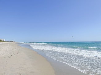 a view of a beach from the shore of the ocean