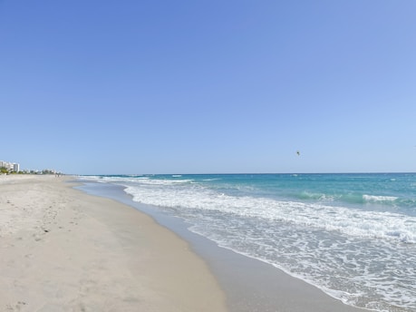 a view of a beach from the shore of the ocean