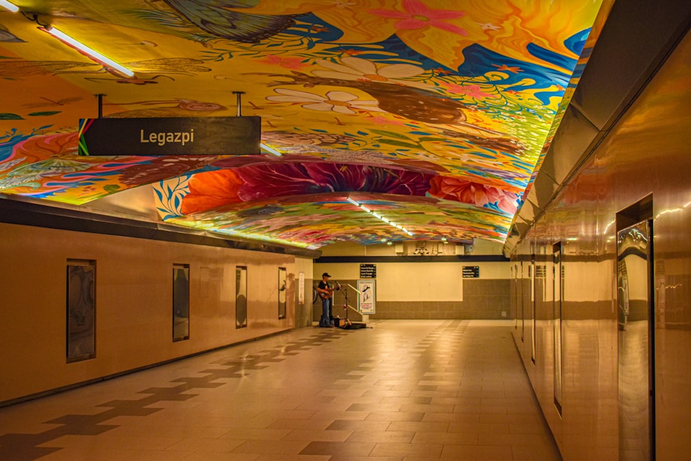 a hallway with a colorful ceiling and tiled floors