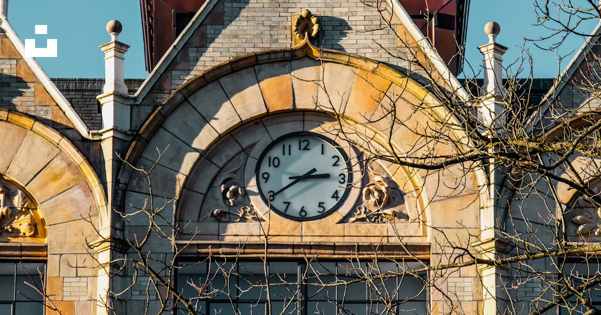 A large building with a clock on the front of it photo – Free ...