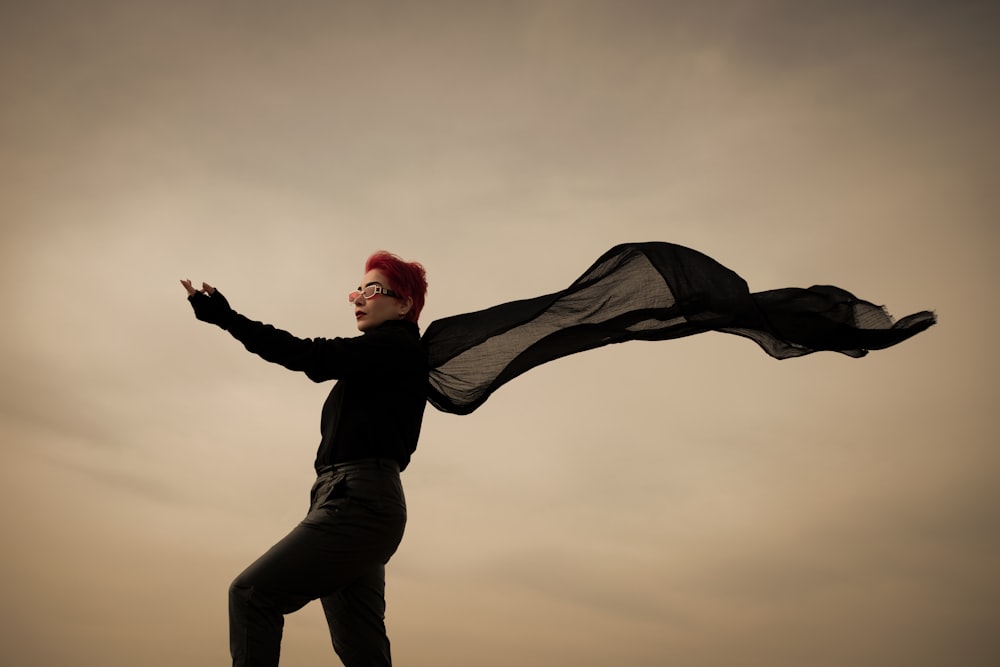 a woman with red hair is flying a kite