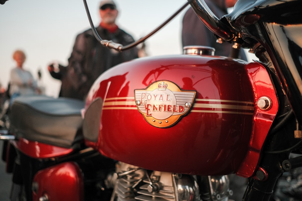 a red motorcycle parked next to a group of people