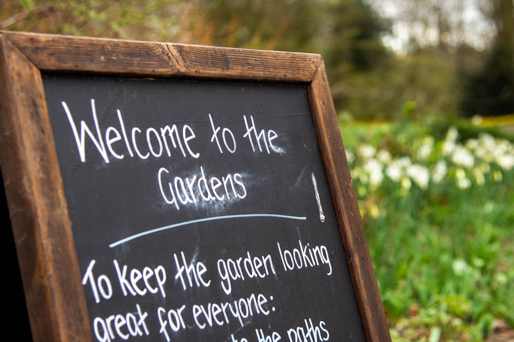 a blackboard sign that says welcome to the gardens