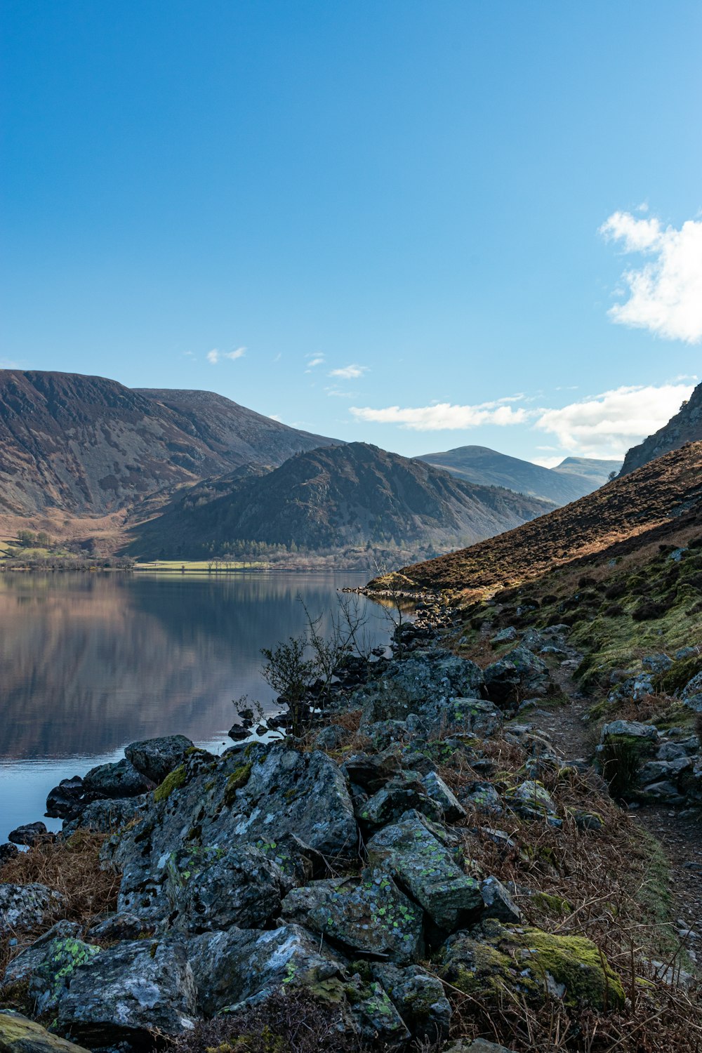 a view of a mountain lake from a rocky shore