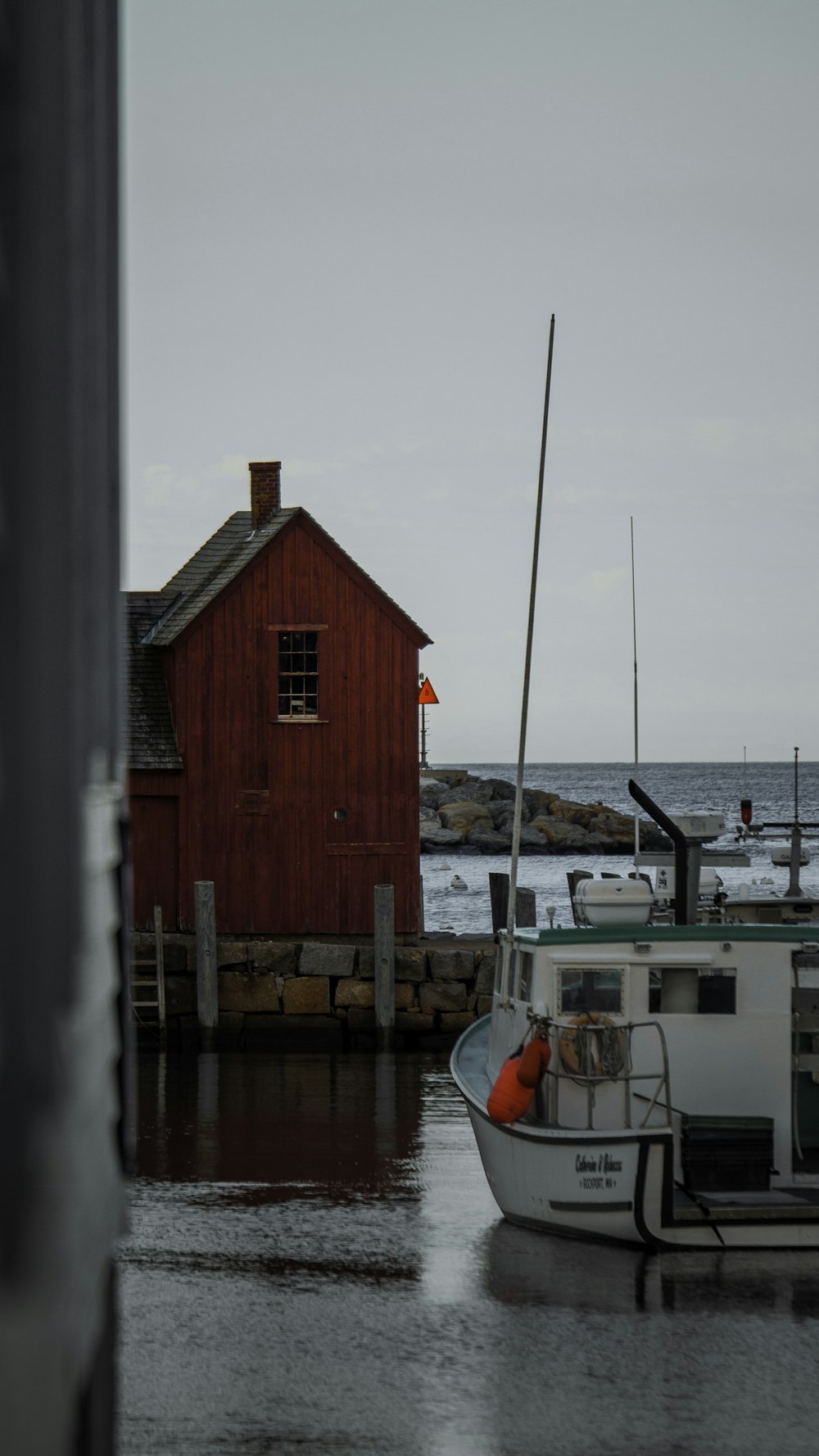 a boat sitting in the water next to a red building