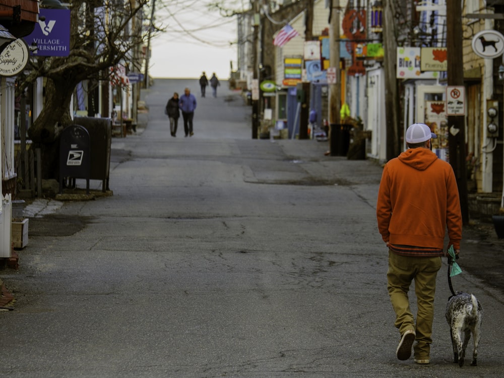 a man walking a dog down a street