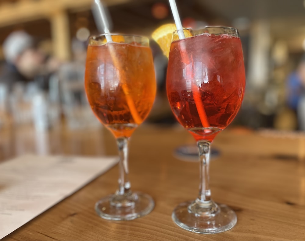 a couple of glasses filled with drinks on top of a table