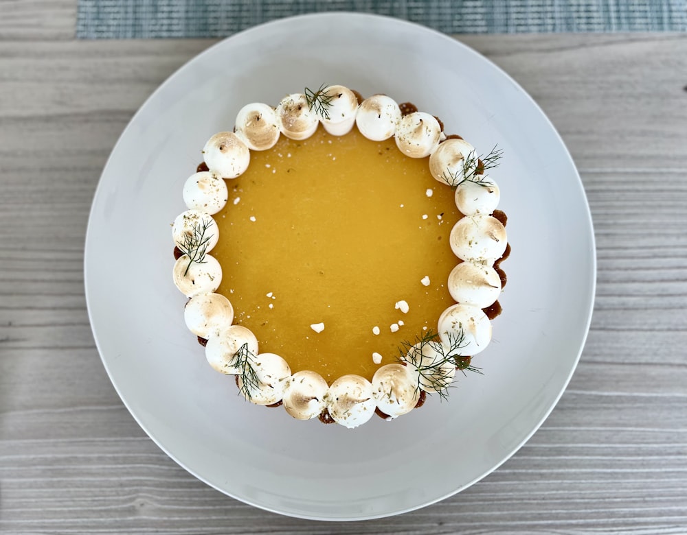 a white plate topped with a dessert covered in whipped cream