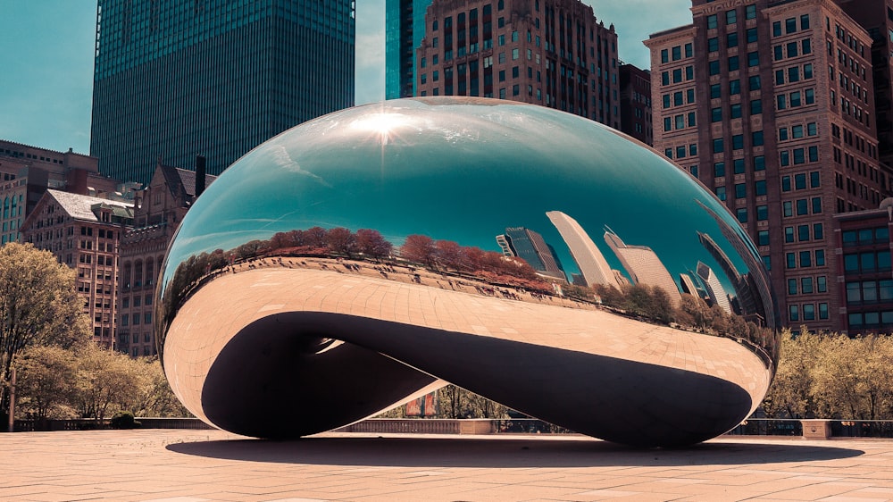 a large metal ball sitting on top of a sidewalk