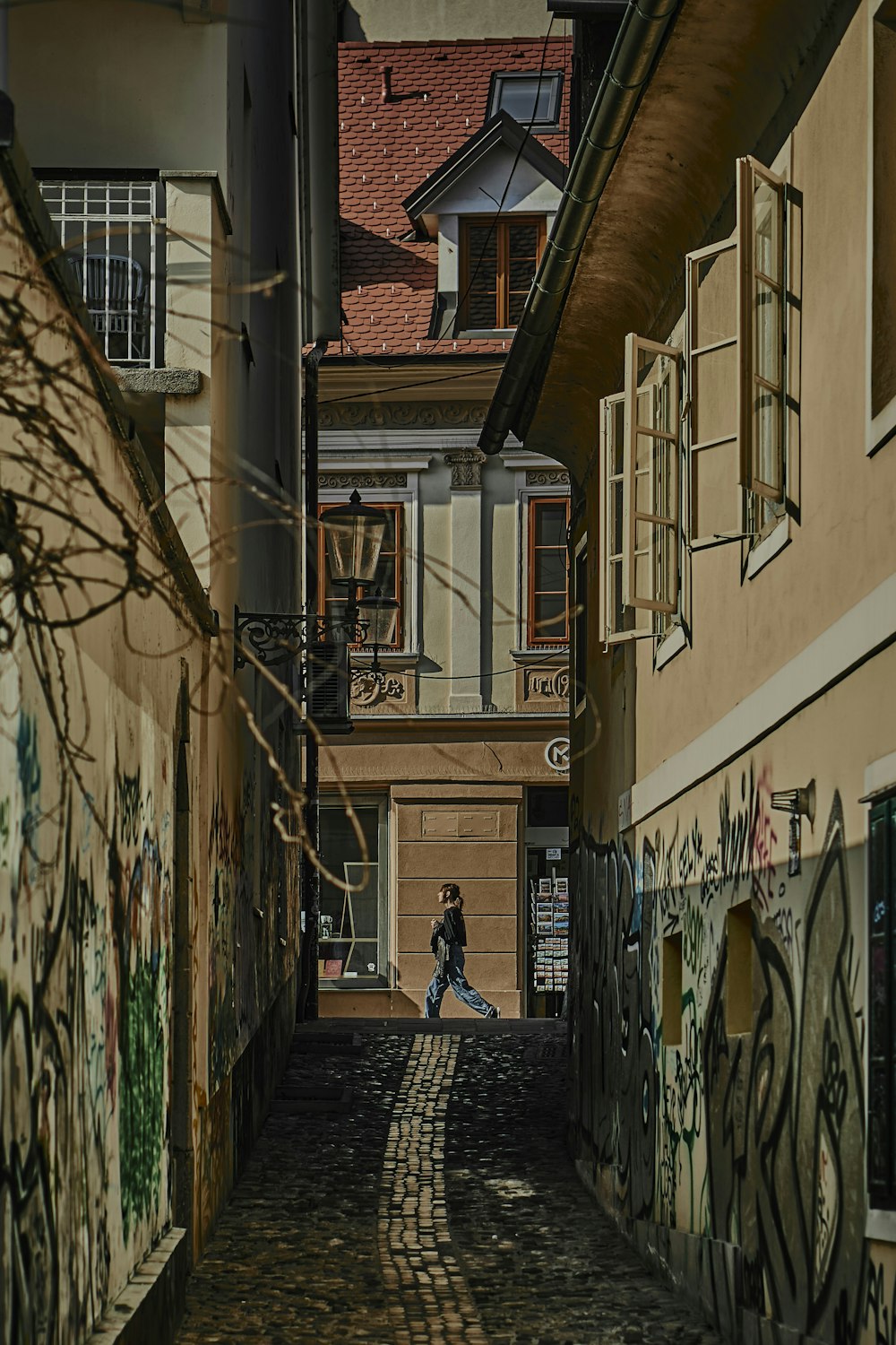 a person sitting on a bench in an alley