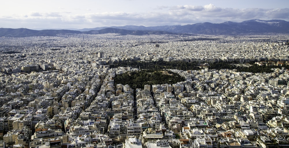 an aerial view of a city with mountains in the background