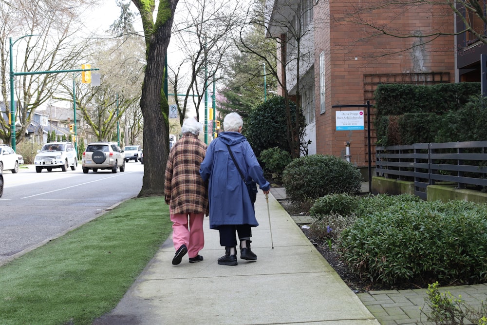 a couple of people walking down a sidewalk