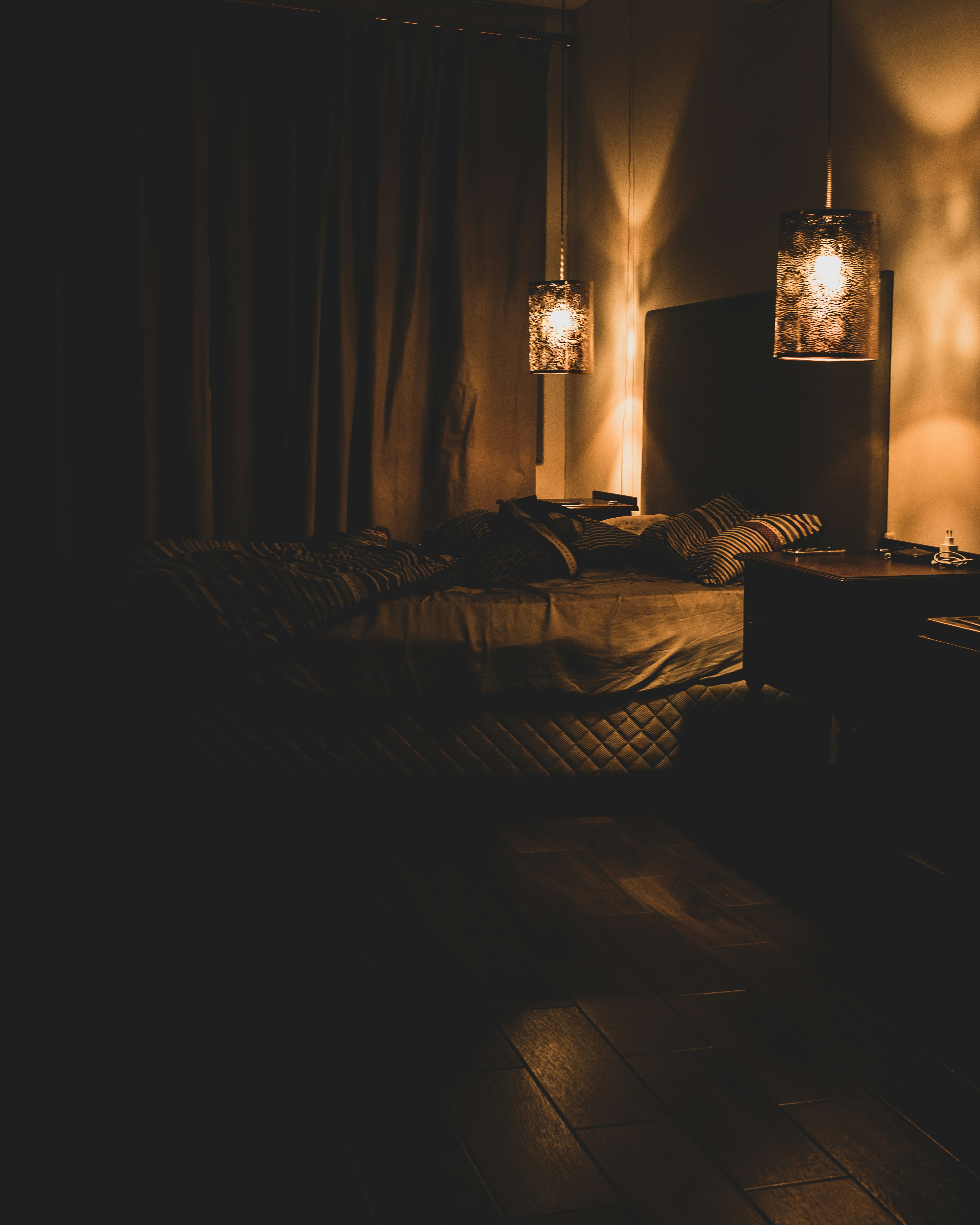 a dimly lit room with a bed and two lamps