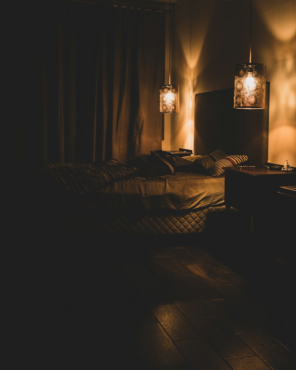 a dimly lit room with a bed and two lamps