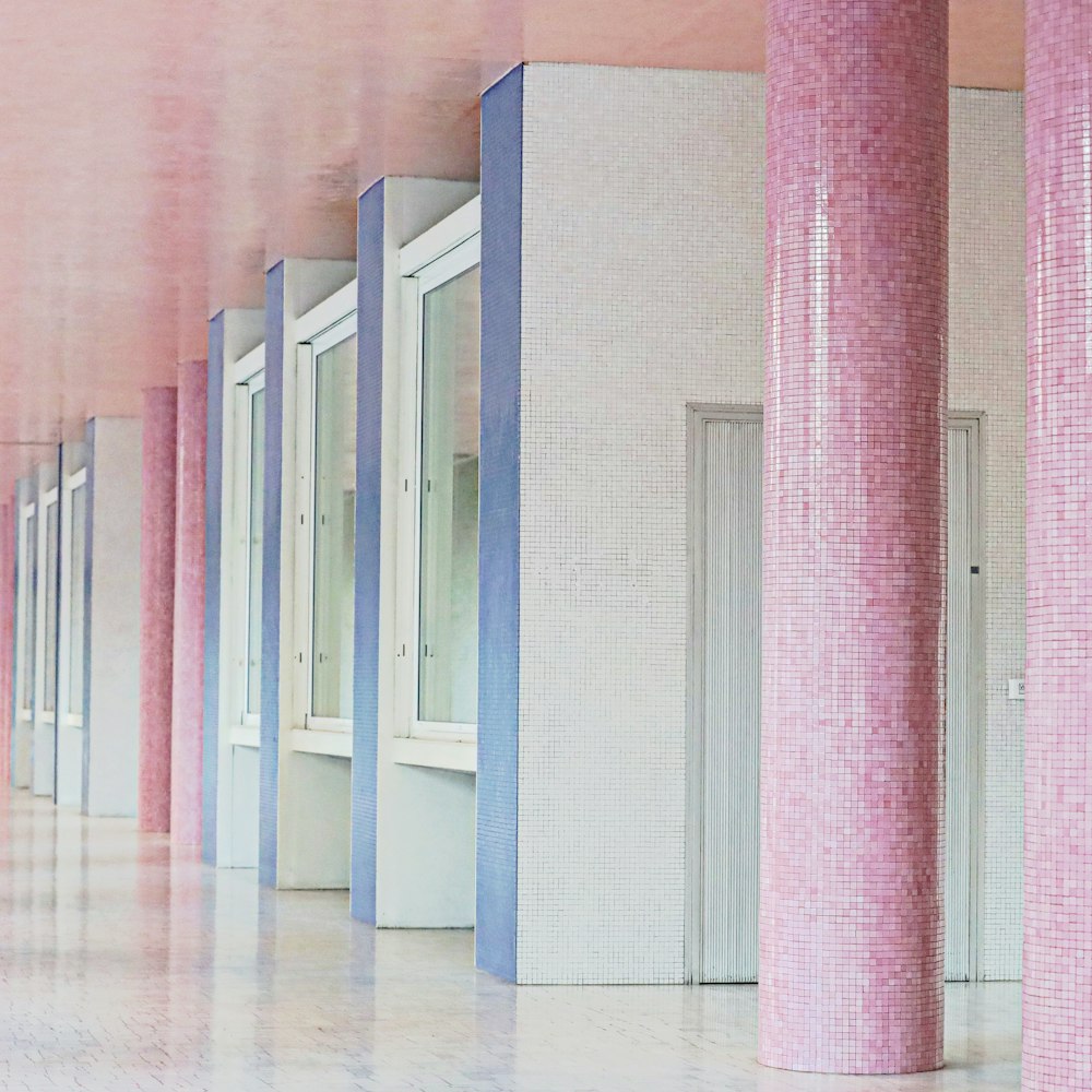 a row of pink and blue columns in a hallway