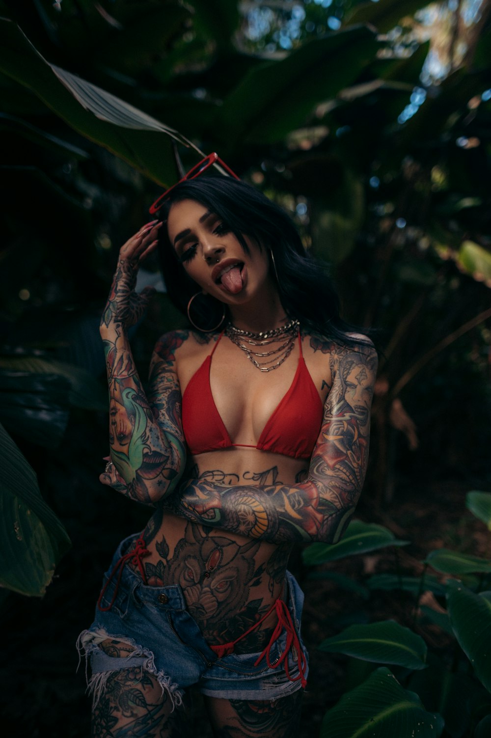 a woman in a red bikini with tattoos on her body