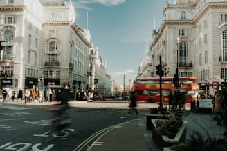 a red double decker bus driving down a street