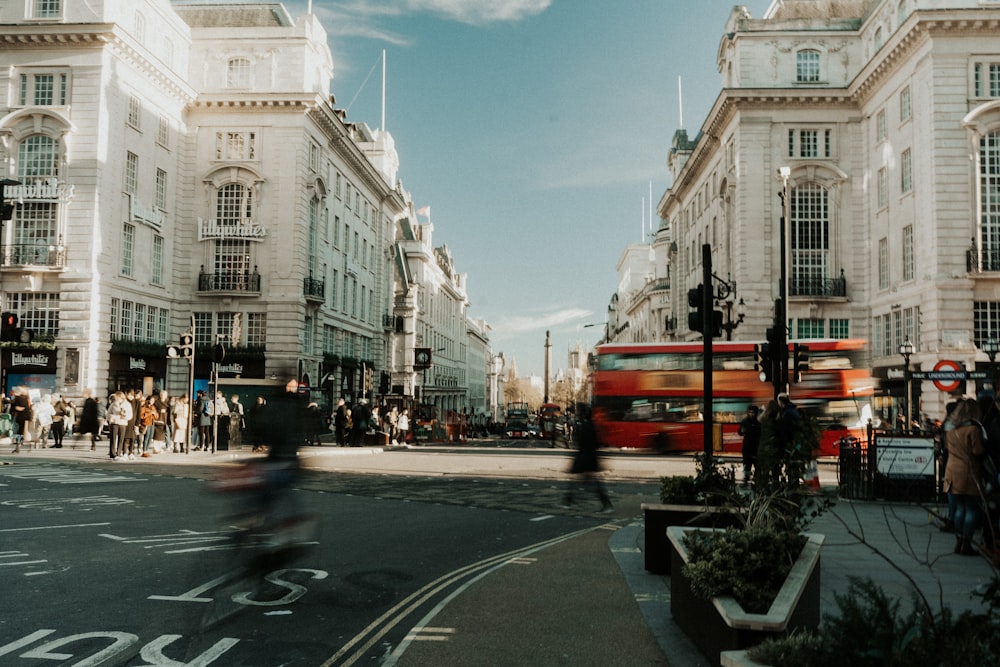 a red double decker bus driving down a street