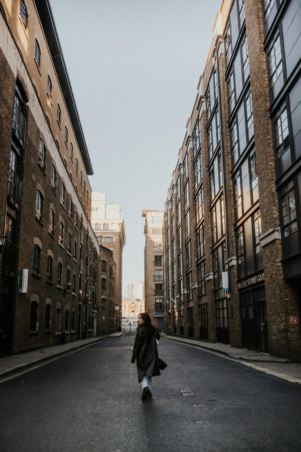 a person walking down a street between two buildings