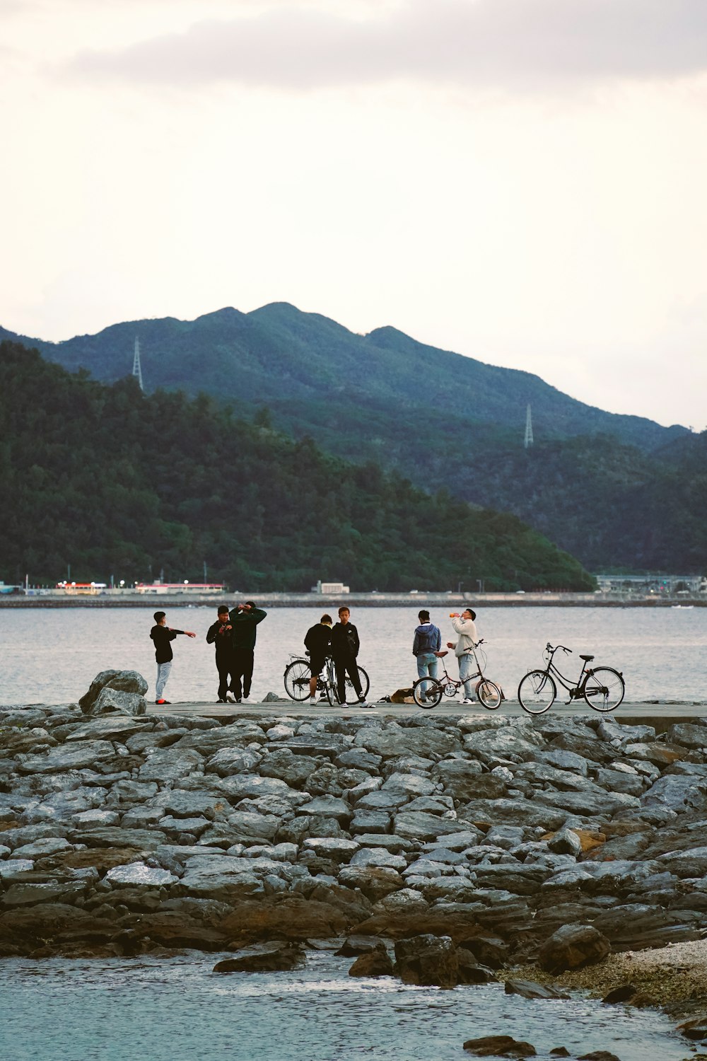 a group of people standing next to a body of water