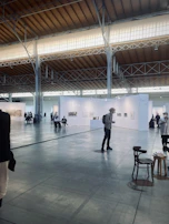 An elegant art exhibition opening with attendees admiring contemporary paintings.