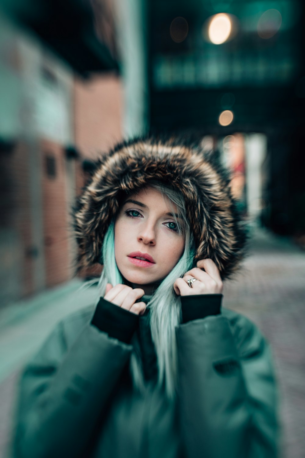 a woman in a green parka with a fur hood