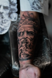 a man with a beard and a beard tattoo on his arm