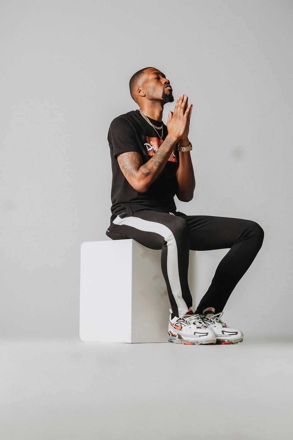 a man sitting on top of a white block